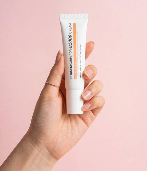 Hand holding a tube of Pharmacian PDRN12000 cream Hand holding a tube of Pharmacian PDRN12000 cream